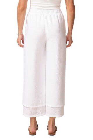 Person wearing white wide-leg pants on a plain background