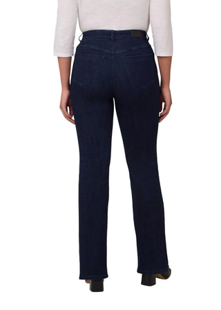 Person wearing dark blue jeans and a white top on a plain background