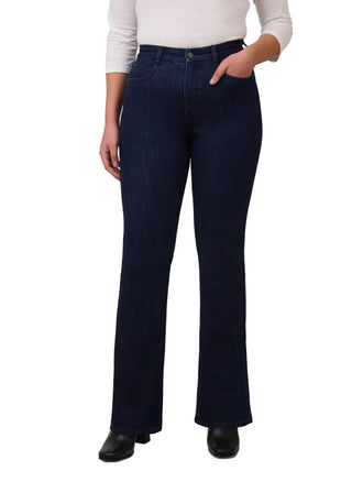 Person wearing dark blue jeans and a white top on a plain background