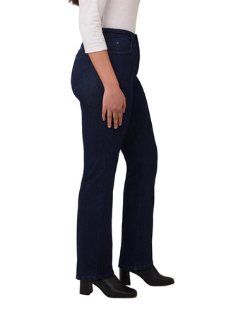 Person wearing dark blue jeans and black boots on a white background