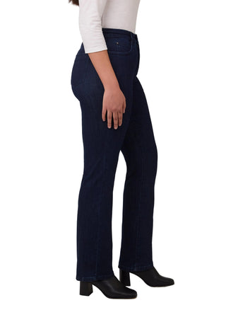 Person wearing dark blue jeans and black shoes on a white background