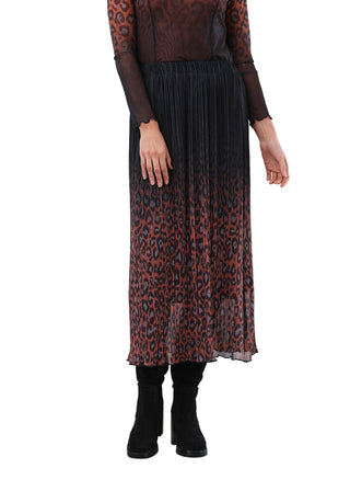Person wearing a pleated skirt with a leopard print pattern on a white background