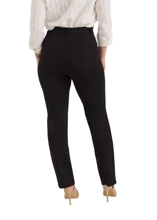 A model shown from the back wearing black high-waisted slim-fit trousers, a white long-sleeve blouse, and beige heels against a light gray studio background.