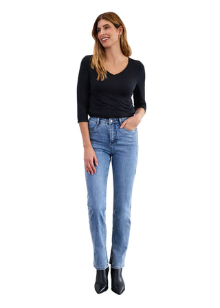 Woman wearing a black top and light blue jeans against a white background