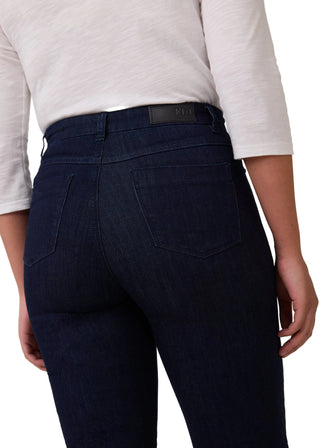 Navy blue jeans with a brand logo on the back pocket against a neutral background