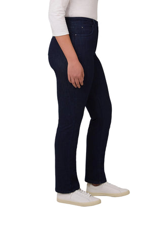 Person wearing dark blue jeans and white sneakers on a light gray background