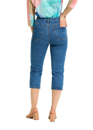 Person wearing blue jeans on a white background