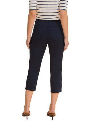 Person wearing navy capri pants and a striped shirt on a beige background