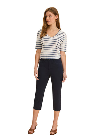 Woman wearing a striped shirt and navy capri pants on a beige background