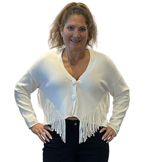 Woman wearing a white cardigan with fringe details against a plain background