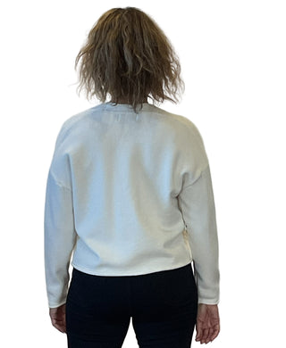 Person wearing a light blue sweater against a white background