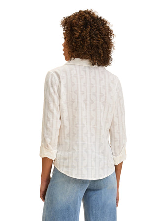 Person wearing a white checkered shirt and blue jeans on a beige background