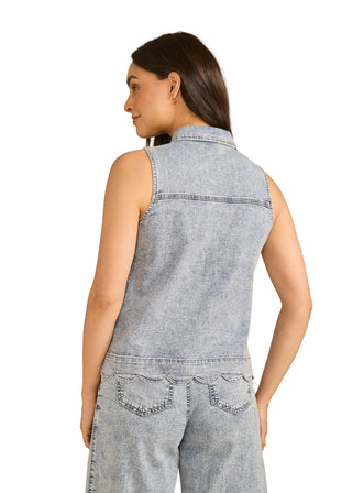 Woman wearing a sleeveless denim top and pants on a beige background