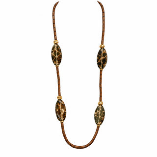 A long brown beaded necklace with four large oval black and brown patterned stone-like beads, displayed on a white mannequin bust against a light gray wall and speckled gray countertop.