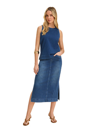 Woman wearing a blue sleeveless top and denim skirt on a beige background