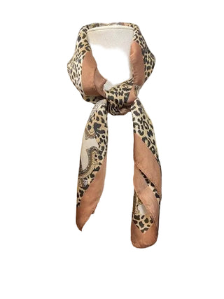 Leopard print scarf on a white stand against a dark background