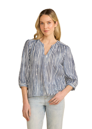 Woman wearing a blue and white striped shirt against a beige background