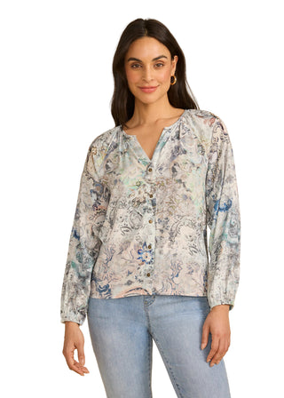 Woman wearing a floral blouse and jeans on a beige background