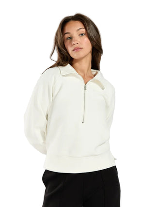 Woman wearing a white zip-up hoodie against a plain background