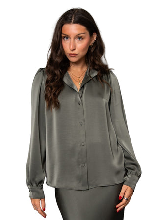 Woman wearing a green blouse against a gray background