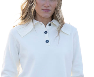 Woman wearing a white shirt with black buttons on a blurred background