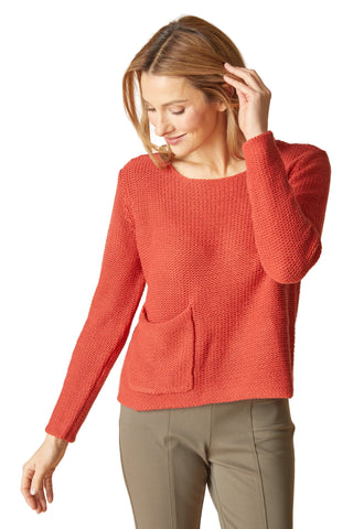 Woman wearing a red sweater with a beige background