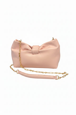 Pink handbag with a gold chain on a gray surface
