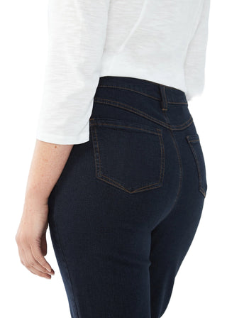 Dark blue jeans worn by a person on a white background
