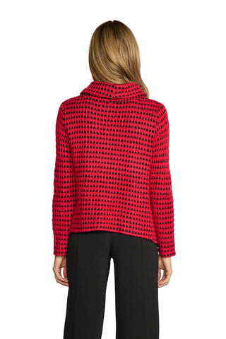 Person wearing a red and black patterned sweater on a plain background