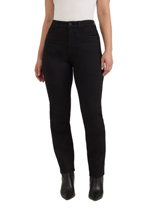 A model wearing black high-waisted slim-fit jeans with a white ribbed top and black pointed-toe ankle boots, standing against a light gray studio background.