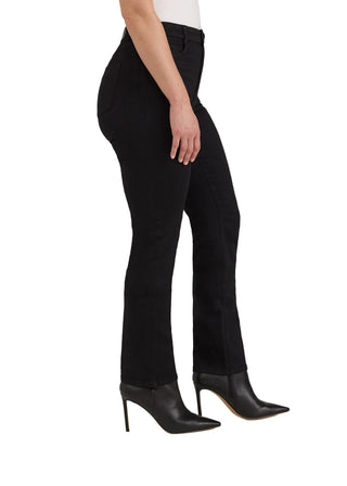 A model shown from the waist down wearing black high-waisted flared pants and black pointed-toe ankle boots, photographed against a plain light beige studio background.