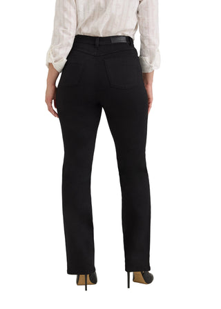 Rear view of a model wearing black high-waisted straight-leg jeans with a black leather belt, paired with a white long-sleeve shirt and black heels with gold toes, against a light gray studio background.