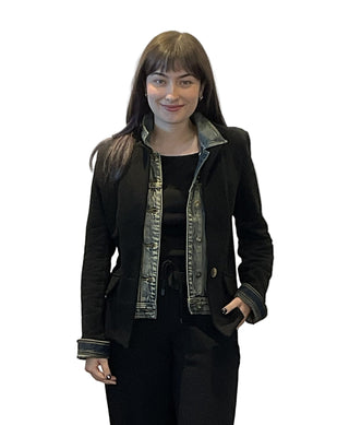 Woman wearing a black jacket with denim collar against a white background