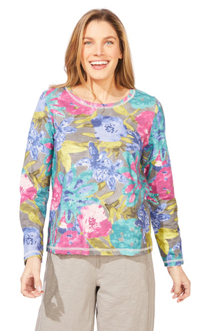 Woman wearing a colorful floral long-sleeve top on a white background