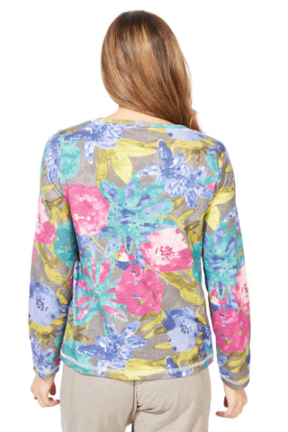 Woman wearing a colorful floral long-sleeve top on a white background