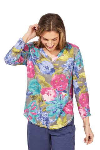 Woman wearing a colorful floral blouse against a white background