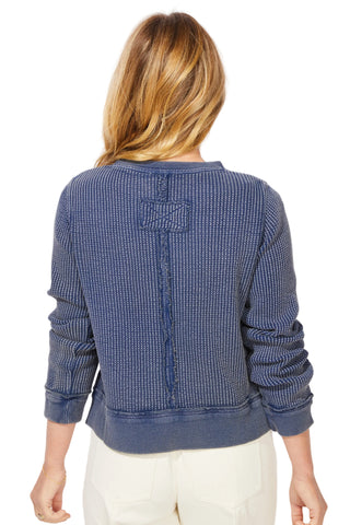 Person wearing a blue textured sweater on a white background