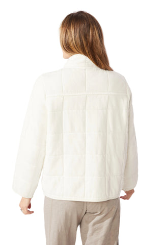 Person wearing a white jacket on a plain background