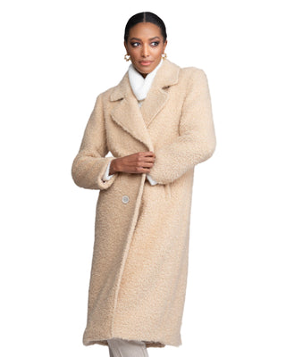 Woman wearing a beige coat against a plain background