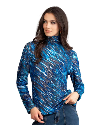 Woman wearing a blue patterned turtleneck shirt against a gray background