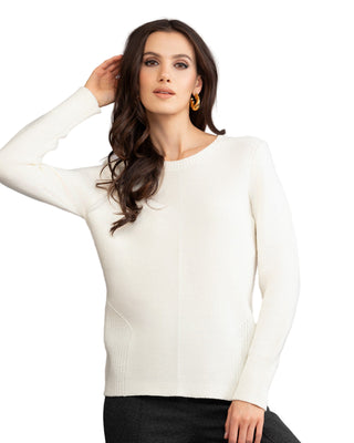 Woman wearing a white sweater against a gray background