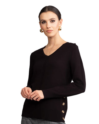 Woman wearing a black sweater with buttons on a gray background