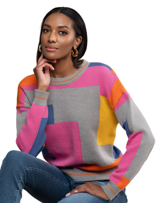 Woman wearing a colorful sweater with a wooden background