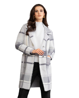 Woman wearing a plaid coat against a plain background