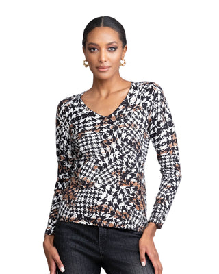 Woman wearing a patterned long-sleeve top against a plain background