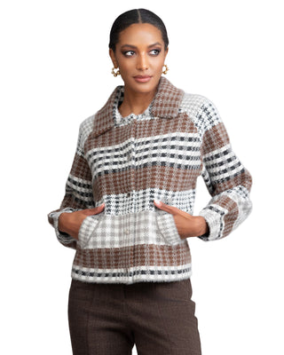 Woman wearing a patterned sweater against a plain background