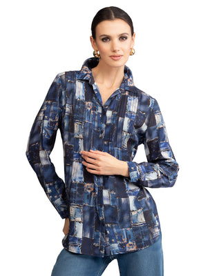Woman wearing a blue patchwork shirt against a gray background