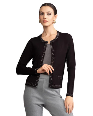 Woman wearing a black cardigan with decorative trim against a gray background