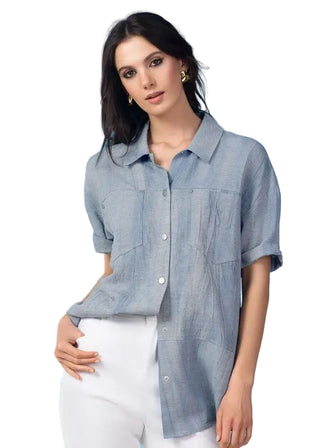 Woman wearing a light blue denim shirt against a light blue background