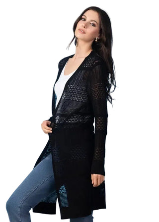 Woman wearing a black long coat with intricate designs against a light blue background